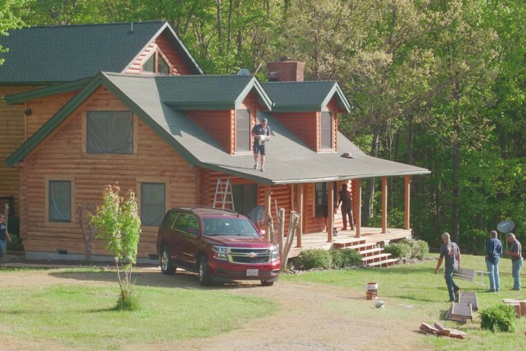 a log cabin surrounded by professionals applying Platinum PRO