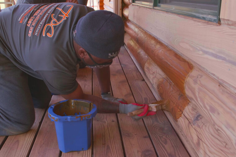 professional applying Platinum PRO to a log cabin