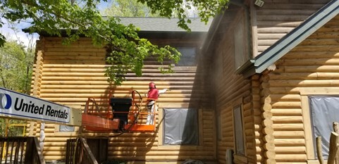 Sand Blasting the coating from wood logs